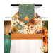 A close up on the top section of the towel, showing details on the floral fabric as well as the fabric button.