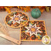A shot of the two completed hot pads slightly overlapping each other on a decorated wooden table.