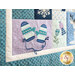 A closer look at the quilt, demonstrating fabric colors, appliqué details, and machine embroidered effects.