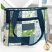 A shot of the tote staged on a white chair with the handles resting at the bag's side to show one side with pockets.