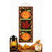 The finished Foundation Paper Piecing Series 3 October project colored in fall and Halloween colors, hung on a golden craft hanger on a white paneled wall above coordinating autumnal decor set on a wooden tabletop.