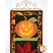 A shot of the top jack-o-lantern block of the project, with part of the fall leaf peeking into frame from the bottom.