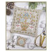 A image of the completed Winter Basket cross stitch pattern staged with snowballs, pinecones, and scissors. 