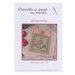 Front of pattern showing a picture of the completed project staged with pink roses and finished with ribbon. 
