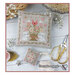 A image of the completed Spring Basket cross stitch pattern staged with baby's breath and scissors. 
