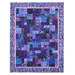 The completed Easy as ABC quilt in purple, blue, and lavender batik fabrics from the Wisteria Blooms collection by Bali Batiks, isolated on a white background.