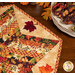 A closer look at the topper, demonstrating the warm fabric colors and prints as well as details on the appliqué leaves.
