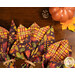A closer look at the four cloth napkins, fanned out on a mahogany table with coordinating fall decor, demonstrating the reversible feature of the napkins.