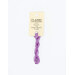 A skein of purple variegated embroidery floss, twisted and bundled, with a cream and black label featuring the brand name and color information.