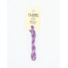 A skein of purple embroidery floss, twisted and bundled, with a cream and black label featuring the brand name and color information.