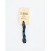 A skein of indigo blue embroidery floss, twisted and bundled, with a cream and black label featuring the brand name and color information.