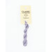 A skein of light periwinkle embroidery floss, twisted and bundled, with a cream and black label featuring the brand name and color information.