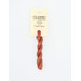 A skein of variegated muted red embroidery floss, twisted and bundled, with a cream and black label featuring the brand name and color information.