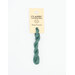 A skein of teal embroidery floss, twisted and bundled, with a cream and black label featuring the brand name and color information.