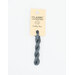 A skein of muted cobalt blue embroidery floss, twisted and bundled, with a cream and black label featuring the brand name and color information.