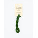 A skein of green embroidery floss, twisted and bundled, with a cream and black label featuring the brand name and color information.