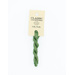 A skein of green embroidery floss, twisted and bundled, with a cream and black label featuring the brand name and color information.