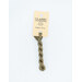 A skein of light sage green embroidery floss, twisted and bundled, with a cream and black label featuring the brand name and color information.