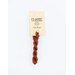 A skein of terracotta orange embroidery floss, twisted and bundled, with a cream and black label featuring the brand name and color information.