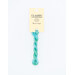 A skein of variegated mint green and aqua blue embroidery floss, twisted and bundled, with a cream and black label featuring the brand name and color information.