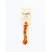 A skein of variegated orange embroidery floss, twisted and bundled, with a cream and black label featuring the brand name and color information.