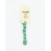A skein of mint green embroidery floss, twisted and bundled, with a cream and black label featuring the brand name and color information.