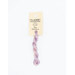 A skein of variegated pink and purple embroidery floss, twisted and bundled, with a cream and black label featuring the brand name and color information.