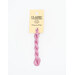 A skein of pink embroidery floss, twisted and bundled, with a cream and black label featuring the brand name and color information.