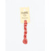 A skein of coral red embroidery floss, twisted and bundled, with a cream and black label featuring the brand name and color information.