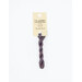 A skein of violet embroidery floss, twisted and bundled, with a cream and black label featuring the brand name and color information.