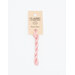 A skein of pastel pink embroidery floss, twisted and bundled, with a cream and black label featuring the brand name and color information.