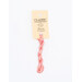 A skein of pink embroidery floss, twisted and bundled, with a cream and black label featuring the brand name and color information.