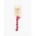 A skein of hot pink embroidery floss, twisted and bundled, with a cream and black label featuring the brand name and color information.