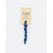 A skein of deep blue embroidery floss, twisted and bundled, with a cream and black label featuring the brand name and color information.