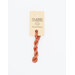 A skein of soft orange embroidery floss, twisted and bundled, with a cream and black label featuring the brand name and color information.