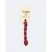 A skein of raspberry red embroidery floss, twisted and bundled, with a cream and black label featuring the brand name and color information.
