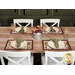 The four completed Self-Binding Placemats, colored in warm autumn fabrics from the Rustle collection by Maywood Studio, staged on a rustic wooden table with white chairs, coordinating flowers, and complementary plates, table ware, napkins, and glasses.
