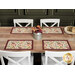 The four completed Self-Binding Placemats, colored in warm autumn fabrics from the Rustle collection by Maywood Studio, staged on a rustic wooden table with white chairs; a tin of coordinating flowers sits in the center.