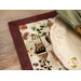 A super close up on the placemat, staged with a golden fork and coordinating table setting.