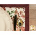 A super close up on the placemat, staged with a golden knife, spoon, and coordinating table setting.