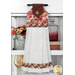 The completed hanging towel in red and orange fall fabrics from the Rustle collection, hung on a kitchen drawer and staged with coordinating flowers and decor.