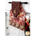 An angled shot of the top fabrics of the towel, showing details on the red and orange leaf prints.