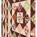 An angled, close up shot of the patchwork center of the quilt, showcasing fabric, piecing, and top stitching details.