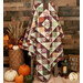A shot of the quilt artfully draped over a wooden ladder to show drape and form, staged with coordinating autumnal décor.