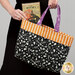 A model holds the tote as she slips a book titled 