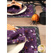A stylized shot of the placemats and cloth napkins on a wooden table, arranged in table settings and staged with coordinating decor.