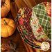 A top down shot of the three stacked bowl cozies, staged with cute pumpkins.