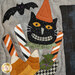 A close up on laser shape decorations on the H block, featuring a boot full of Halloween treats, a grinning black cat, and a flying bat.