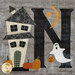 A close up on the N block, featuring a ghost trick-or-treating at a haunted house.
