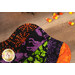 A stylized top-down close up on one of the bowl cozies, demonstrating fabric colors and print details. Tossed candy corn peeks into frame from the top.